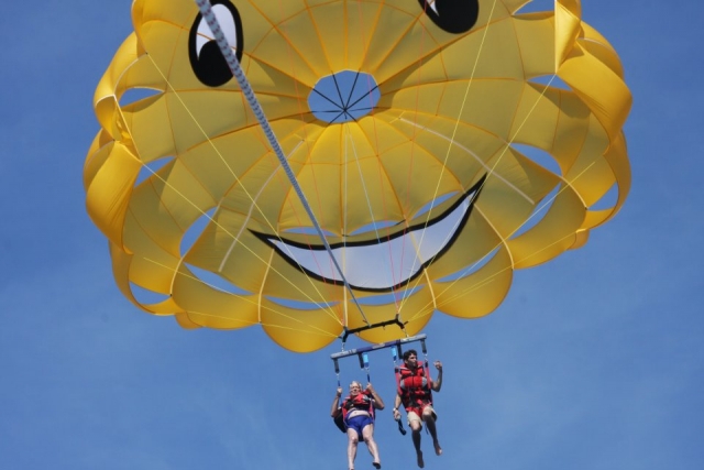 paracidas de una cara sonriente con dos personas volando